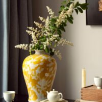Elegant yellow orchid arrangement in ceramic vase