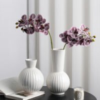 Wabiv spherical ceramic vase with vertical striped texture in minimalist studio setting