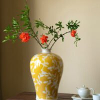 Elegant yellow orchid arrangement in ceramic vase