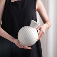 Wabiv spherical ceramic vase with vertical striped texture in minimalist studio setting
