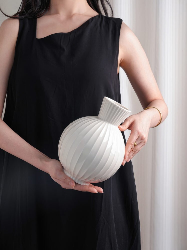 Wabiv spherical ceramic vase with vertical striped texture in minimalist studio setting