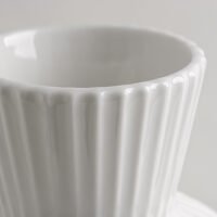 Wabiv spherical ceramic vase with vertical striped texture in minimalist studio setting