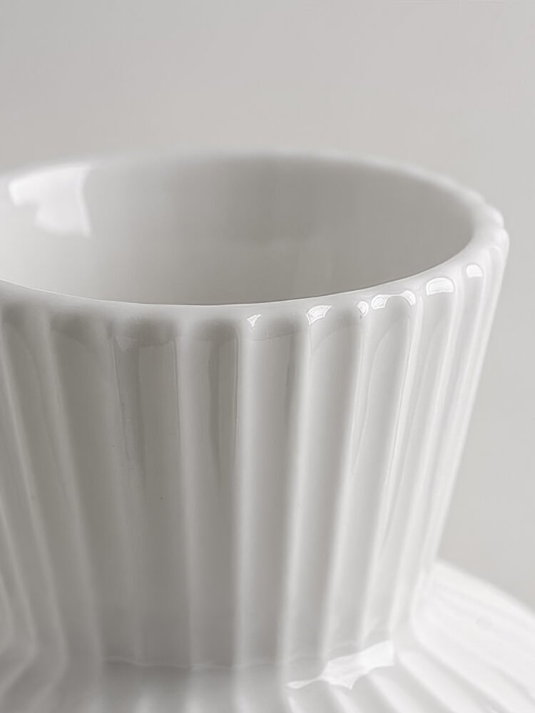 Wabiv spherical ceramic vase with vertical striped texture in minimalist studio setting