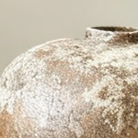 Vintage wabi-sabi style rustic pottery vase with weathered stone texture