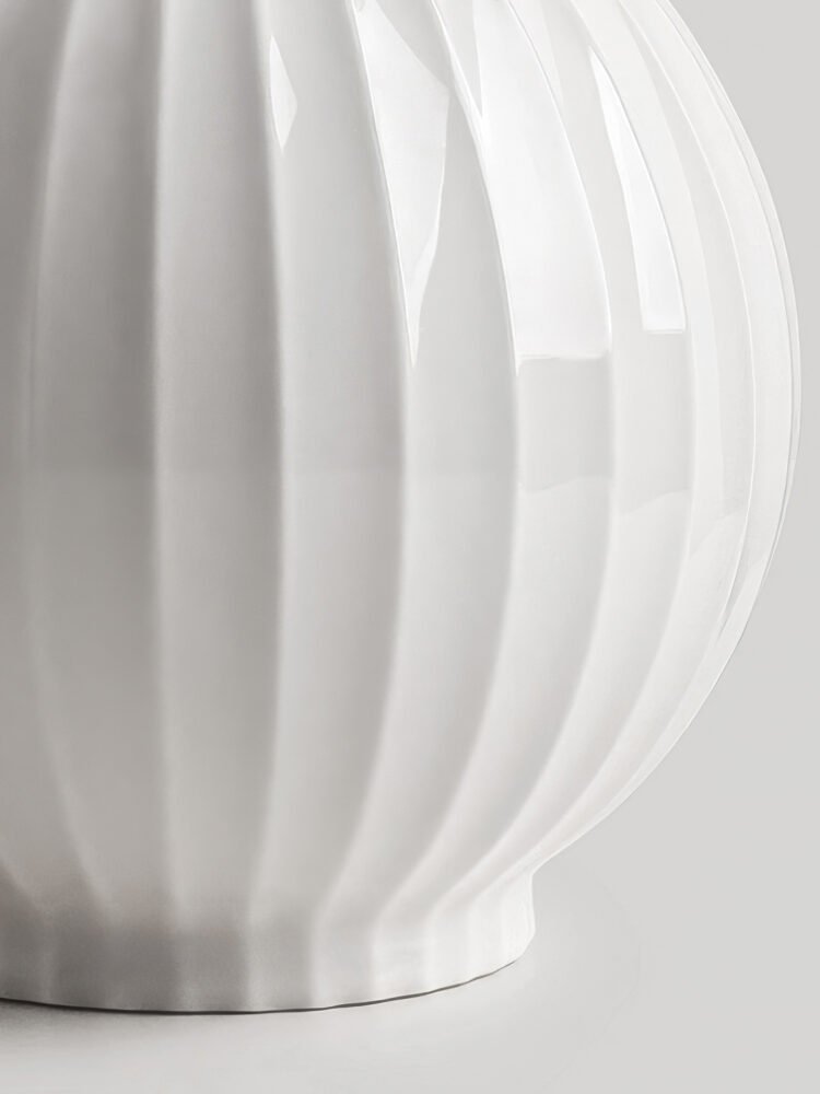 Wabiv spherical ceramic vase with vertical striped texture in minimalist studio setting