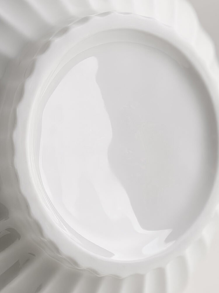 Wabiv spherical ceramic vase with vertical striped texture in minimalist studio setting