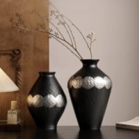 Handmade wabi-sabi style silver-glazed ceramic vase on a minimalist wooden table