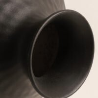 Handmade wabi-sabi style silver-glazed ceramic vase on a minimalist wooden table