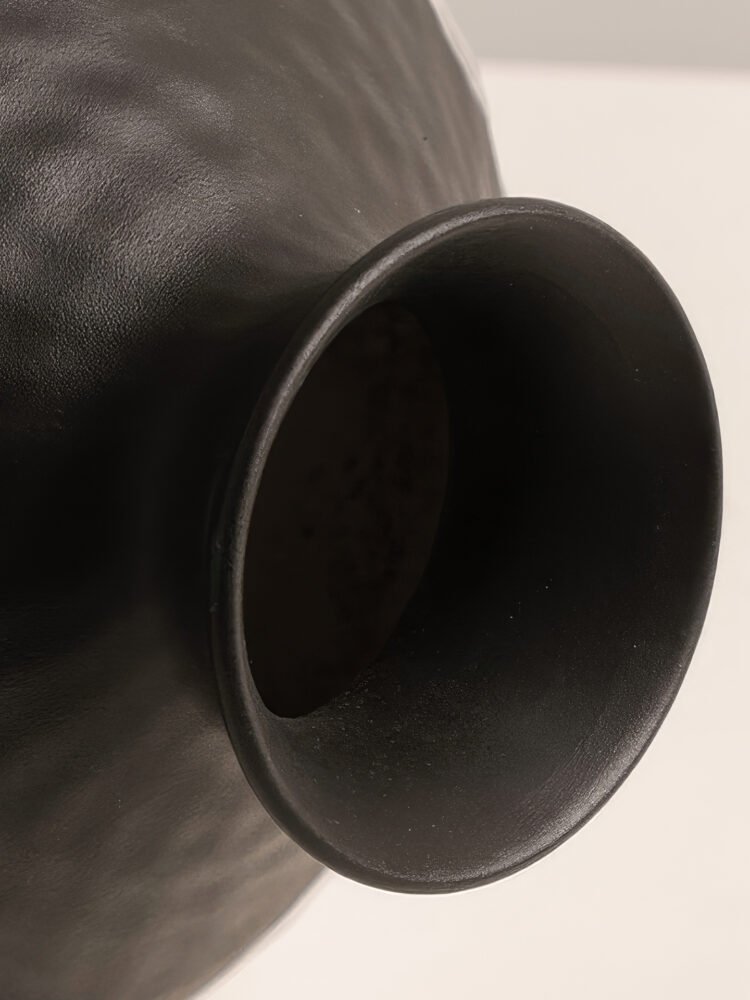 Handmade wabi-sabi style silver-glazed ceramic vase on a minimalist wooden table