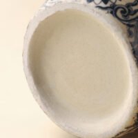 Vintage blue and white porcelain vessel with intricate vine motif pattern